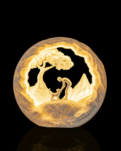 Best Friend Table Lamp illuminated from the front, showing a person greeting a cat beneath a tree
