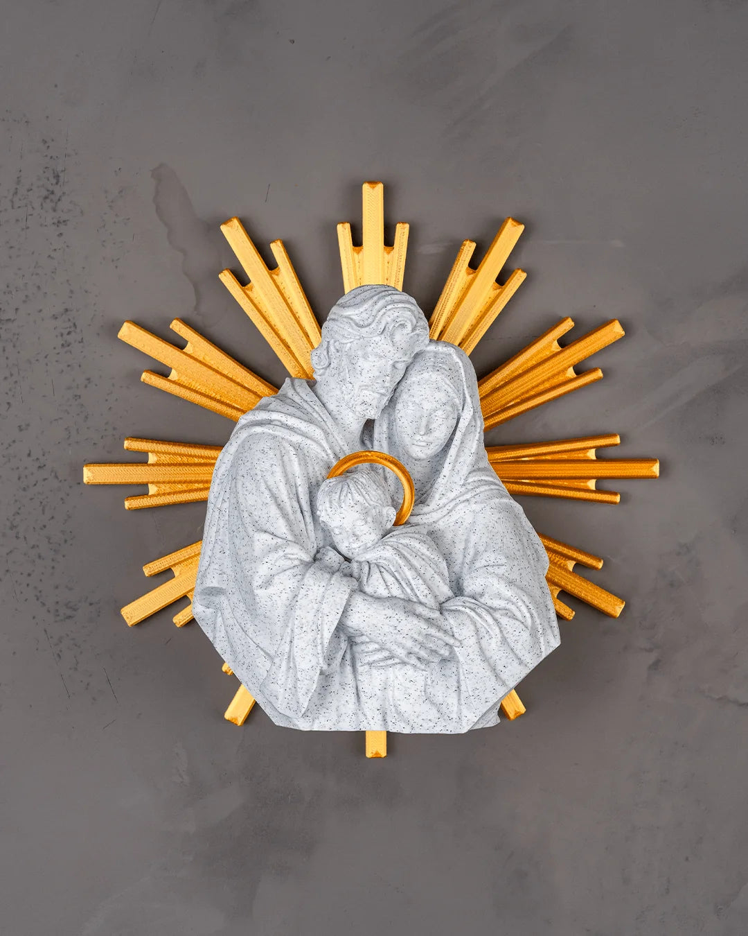 The Holy Family wall decor in marble and gold on a light gray wall